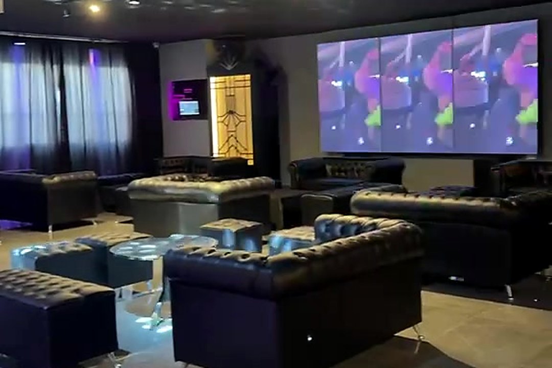 Otro ángulo del sector lounge con la pantalla LED encendida