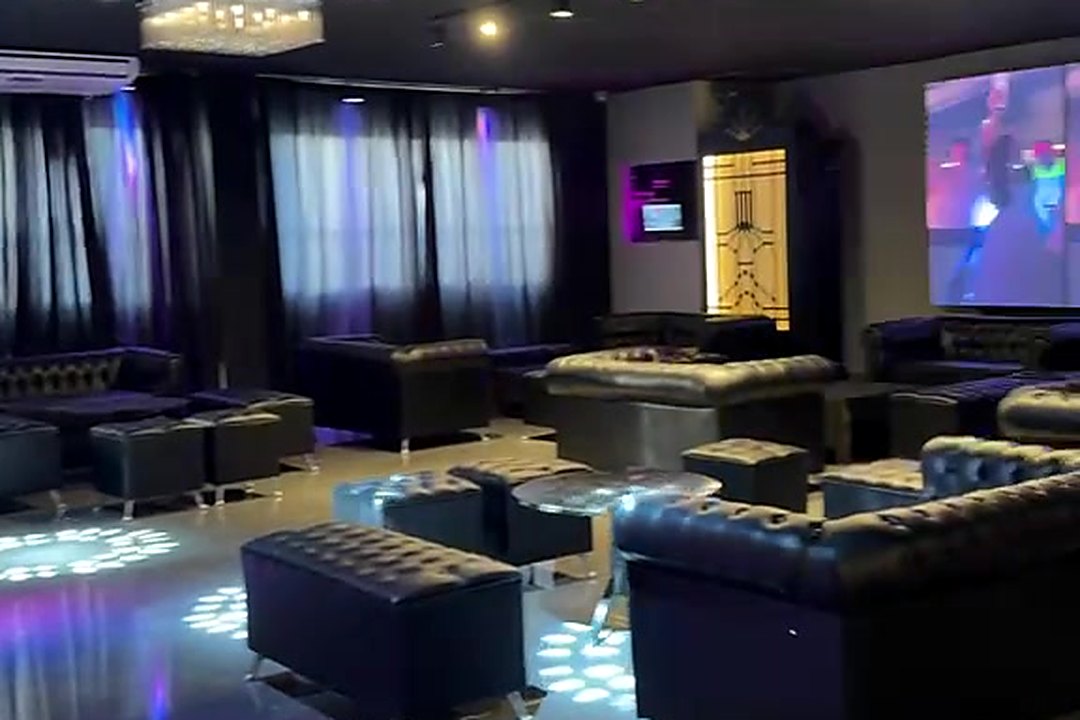 Sector lounge del Salón Recepción con sillones chesterfield, mesas bajas espejadas, pantalla LED y luces sobre el piso
