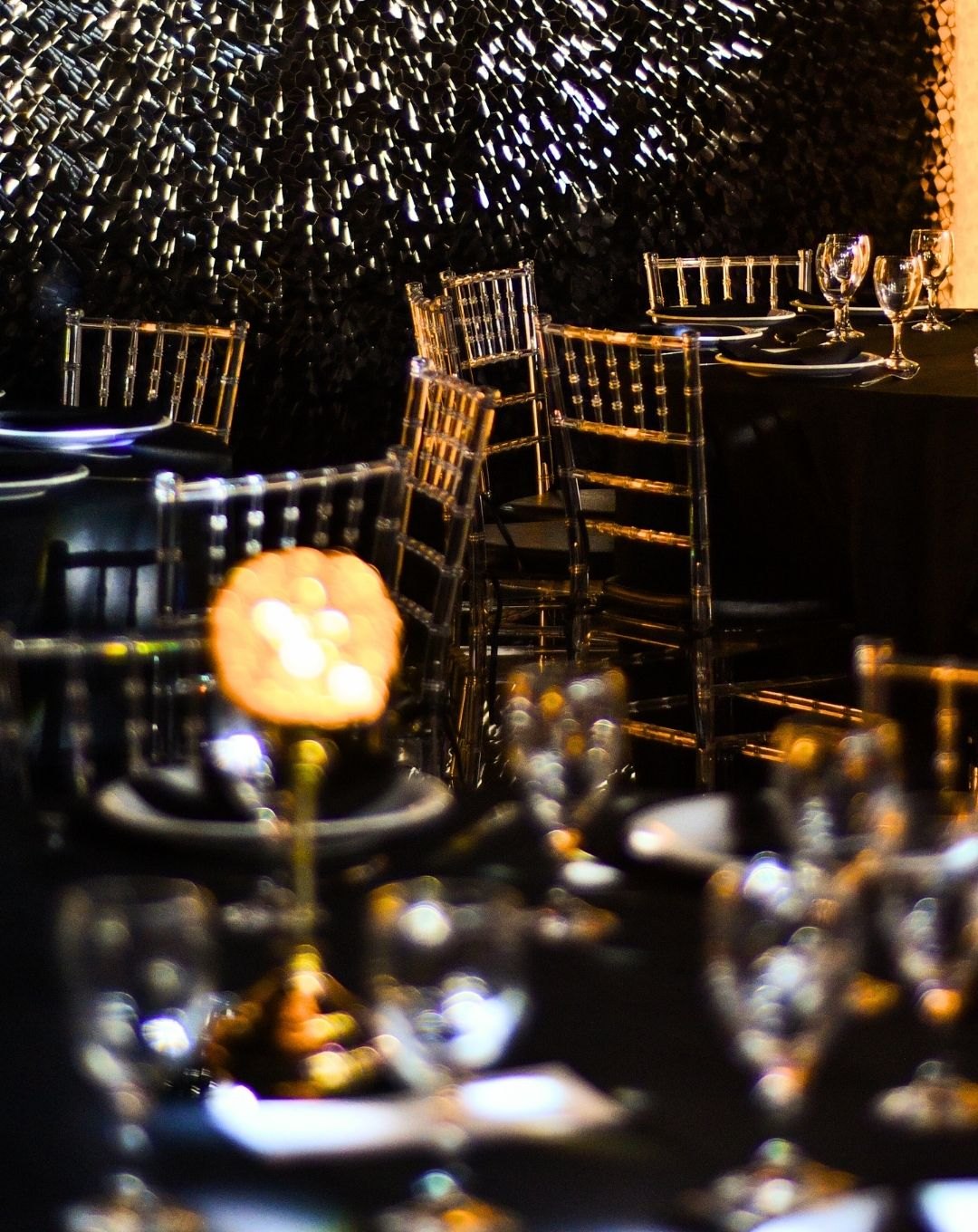 Mesas vestidas de negro con sillas Tiffany cristal y centros de mesa iluminados